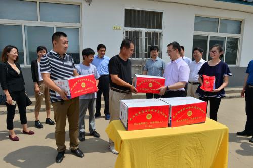 图为农业部兽医局相关负责人向当地养殖户送“放心兽药”。